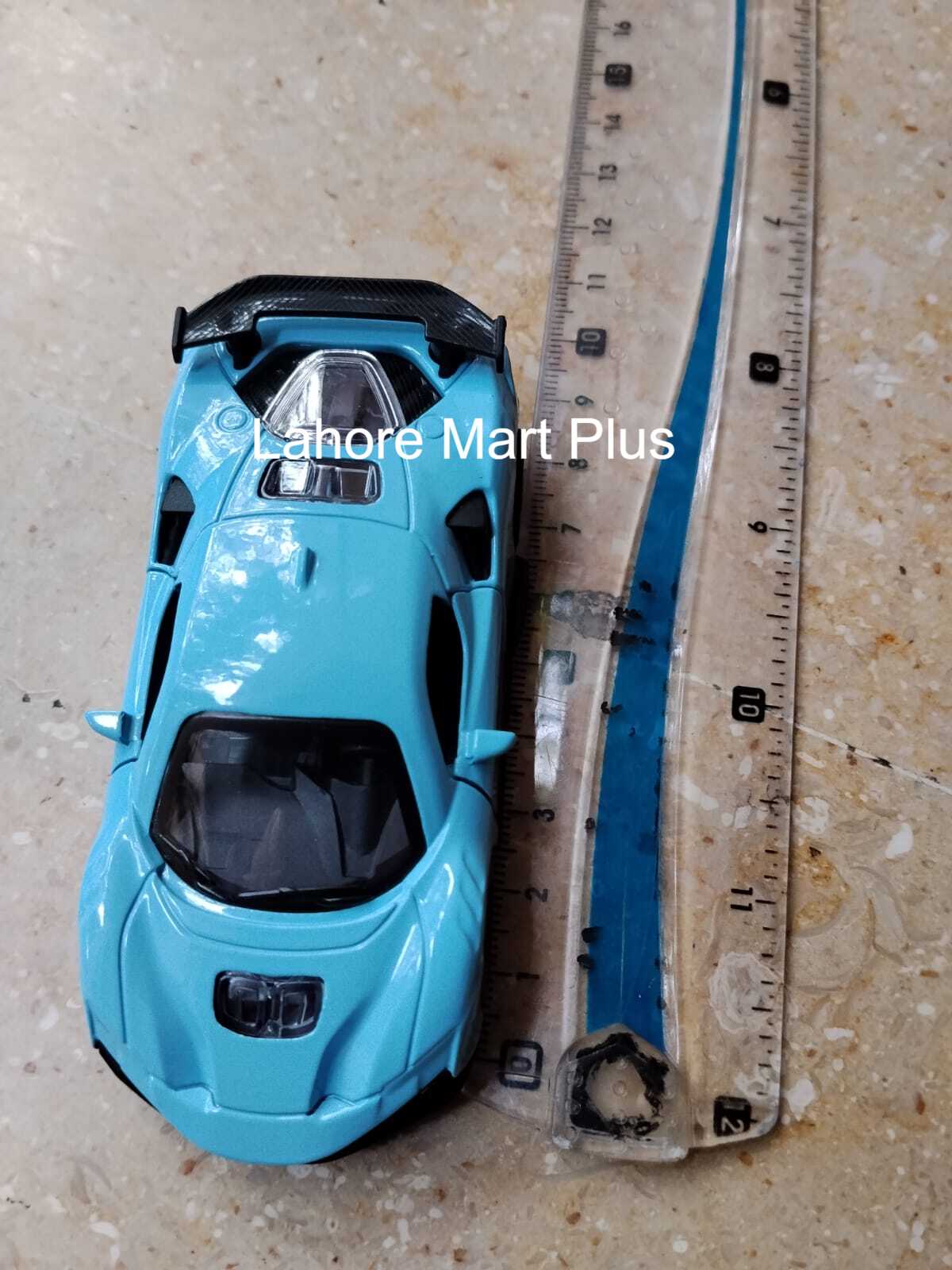 Blue metal toy sports car shown beside a ruler
